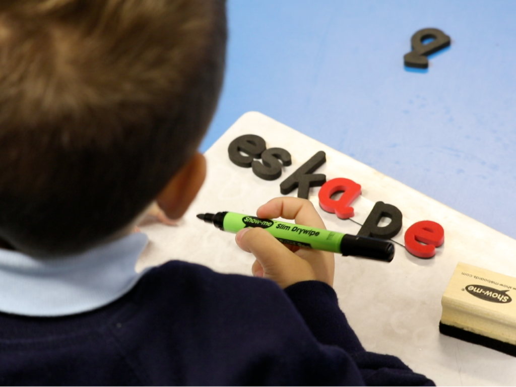 Child using the monster phonics magnetic letters in a classroom